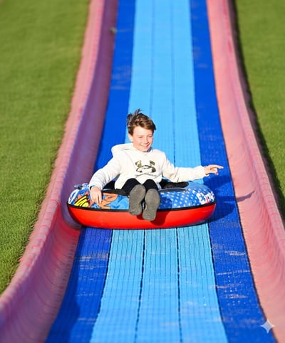 Young boy sliding down Randy's Thrill Hill, the super mega slide at Bear Paw Adventure Park, during the summer. Young boy sliding down Randy's Thrill Hill, the super mega slide at Bear Paw Adventure Park, during the summer.
