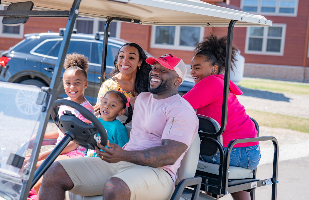 Family enjoying a ride on a golf cart - best way to get around the campground