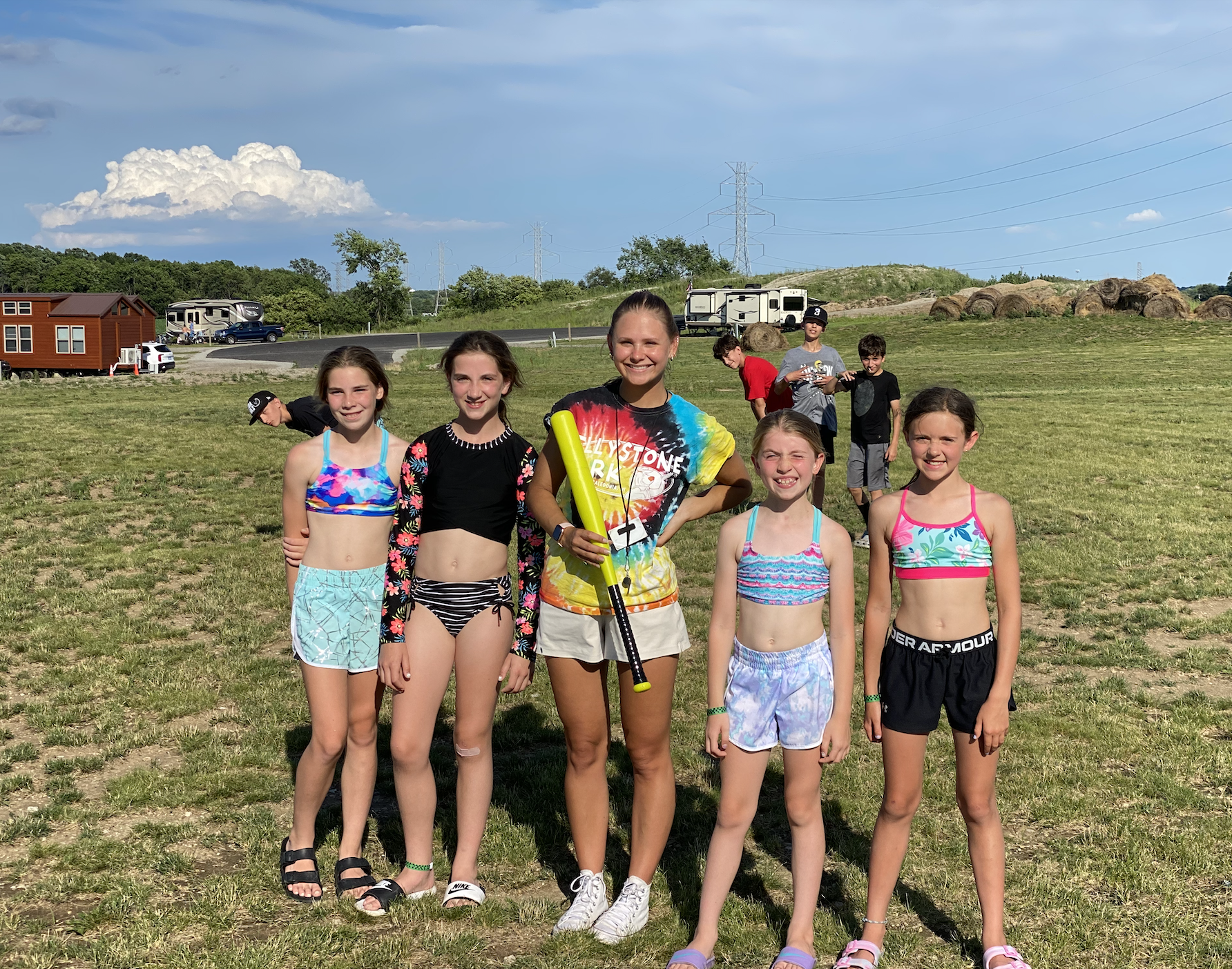 Group of girls play wiffle ball at Bear Paw Adventure Park on a warm summer day.